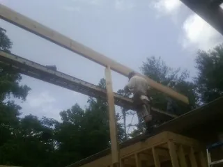 Carpenter setting a ridge beam over a new addition frame — Ice Dam Removal by Roofing Brothers in Little Rock